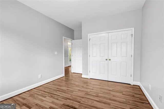 unfurnished bedroom with a closet and wood-type flooring