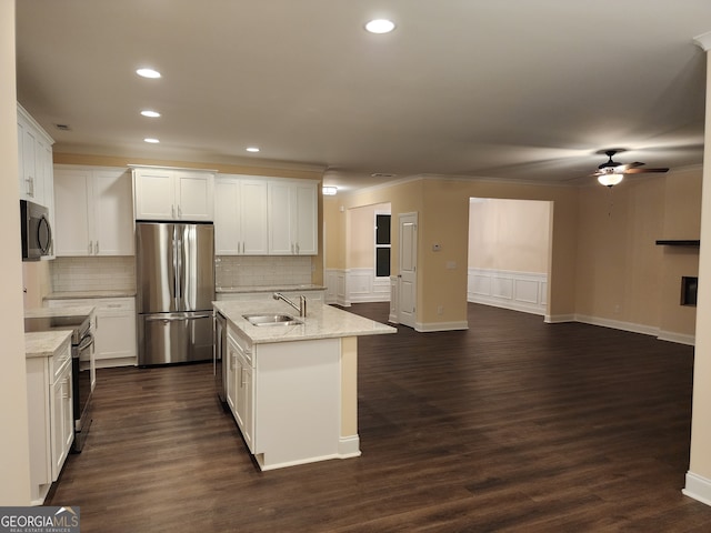 kitchen with light stone countertops, dark wood-type flooring, stainless steel appliances, a center island with sink, and white cabinets