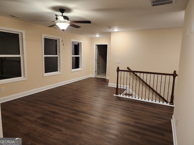 unfurnished room with ceiling fan and dark wood-type flooring