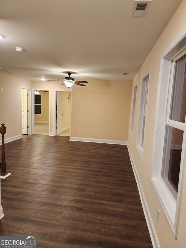 unfurnished living room featuring ceiling fan and dark wood-type flooring