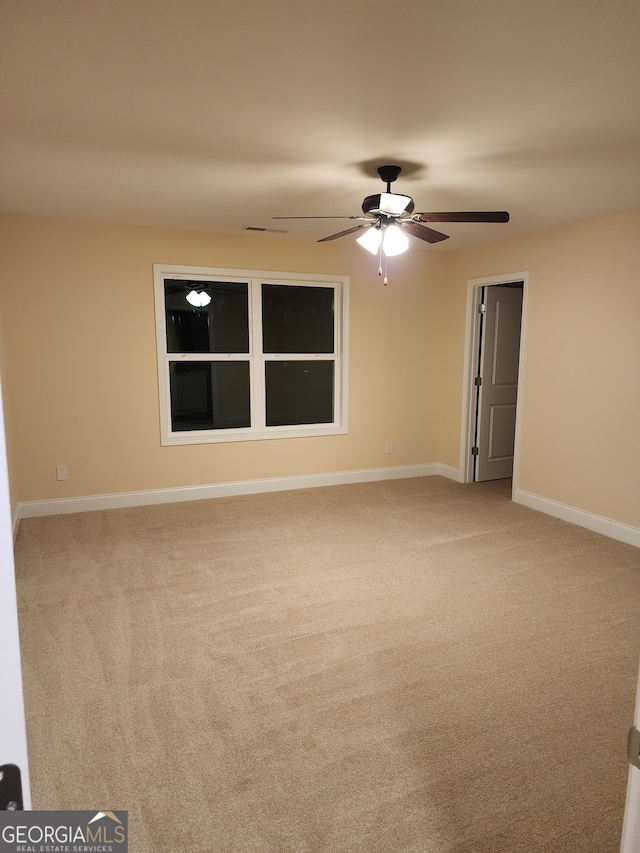 carpeted spare room with ceiling fan