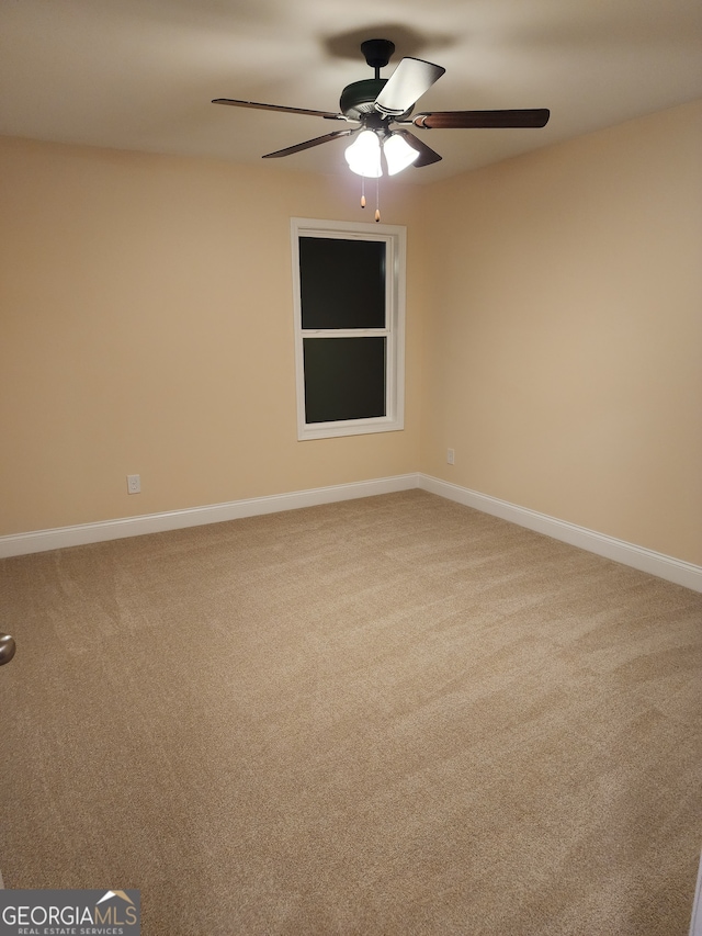 carpeted spare room featuring ceiling fan