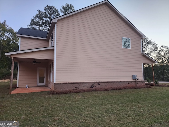 view of property exterior featuring a patio area, ceiling fan, and a yard