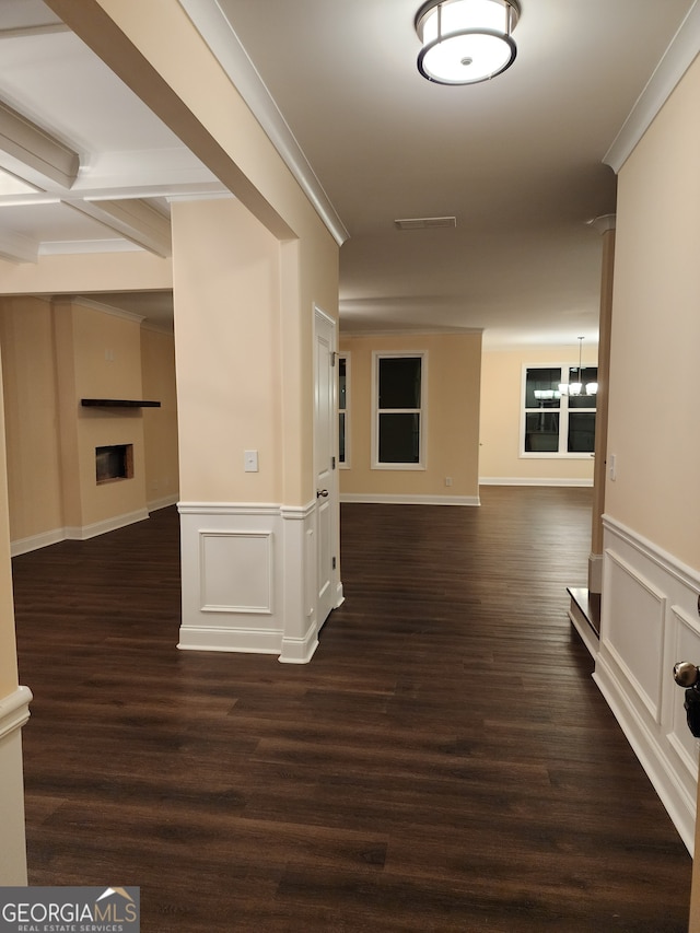 corridor with dark hardwood / wood-style floors and ornamental molding