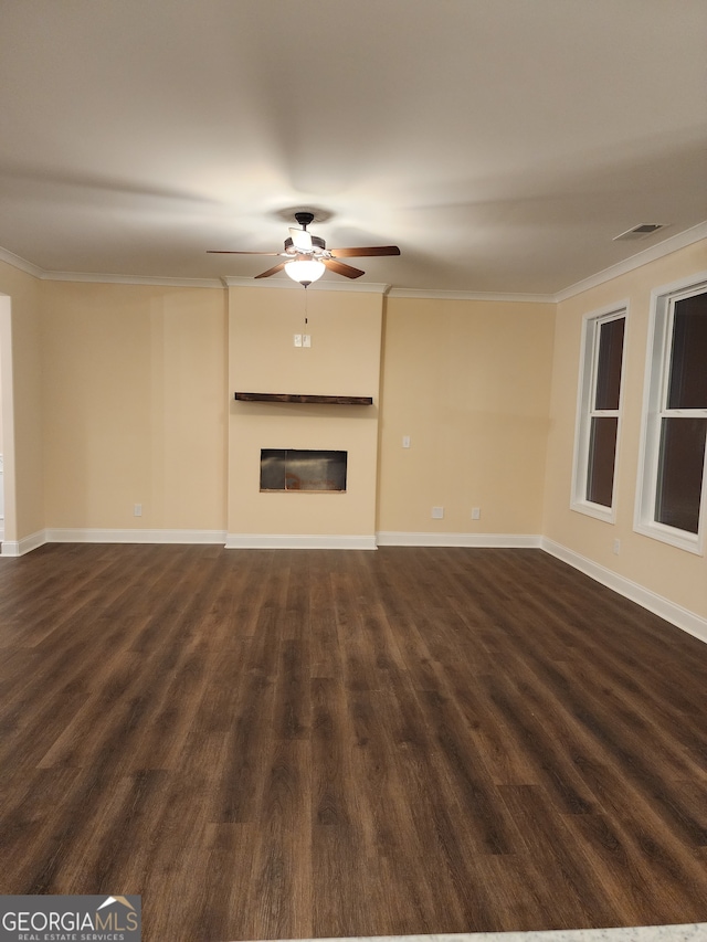 unfurnished living room featuring dark hardwood / wood-style floors, ceiling fan, and crown molding