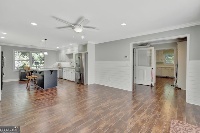 living room featuring dark hardwood / wood-style flooring, sink, crown molding, and a wealth of natural light