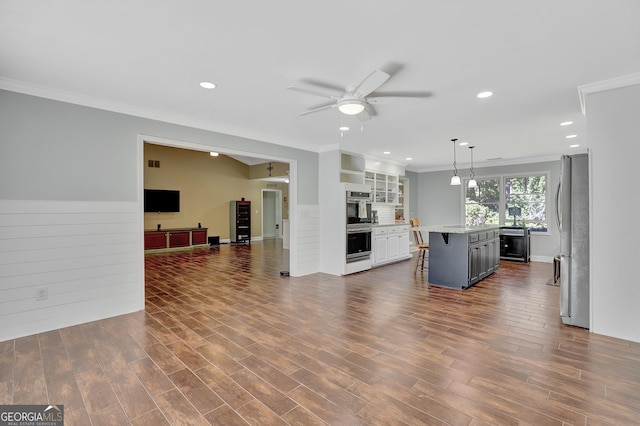 kitchen with a breakfast bar area, white cabinetry, a center island, appliances with stainless steel finishes, and pendant lighting