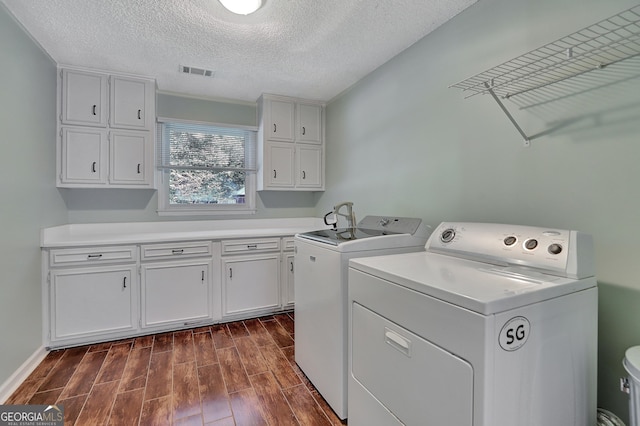 laundry area with separate washer and dryer and a textured ceiling