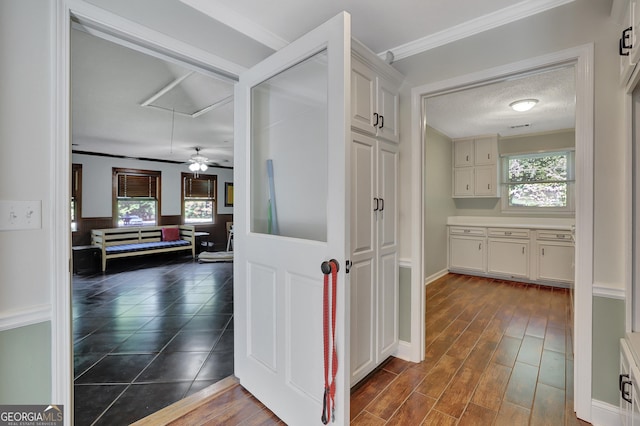 hall featuring ornamental molding, a textured ceiling, and dark hardwood / wood-style flooring