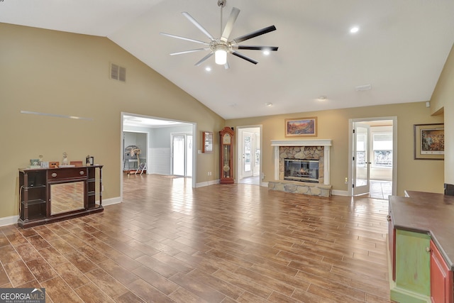 living room with ceiling fan, a fireplace, high vaulted ceiling, and wood-type flooring