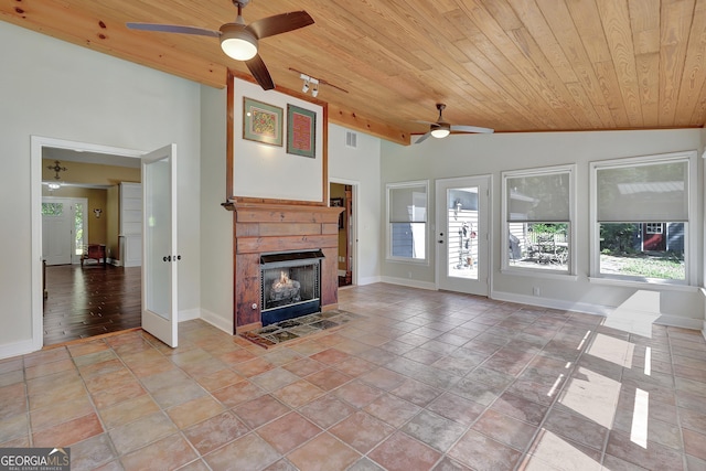 unfurnished living room featuring wood ceiling, vaulted ceiling, light tile patterned floors, ceiling fan, and a fireplace