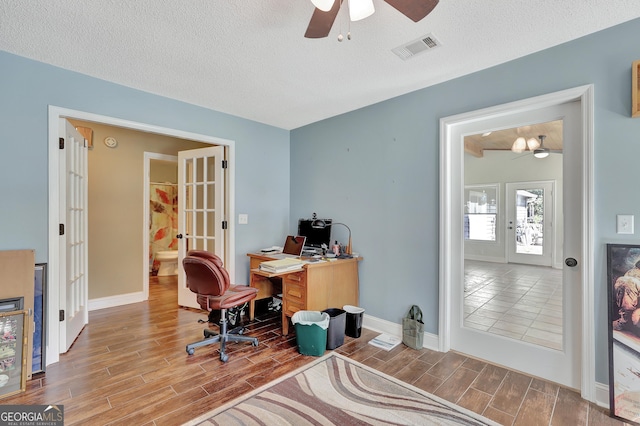 home office with ceiling fan, french doors, and a textured ceiling