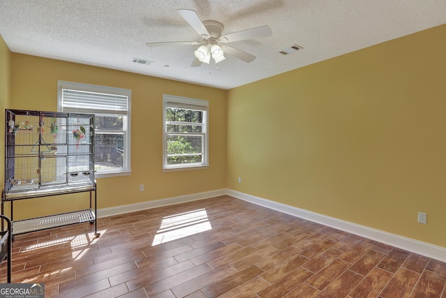 empty room featuring a textured ceiling and ceiling fan