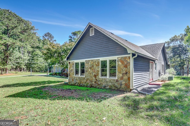 view of property exterior with a lawn and central air condition unit