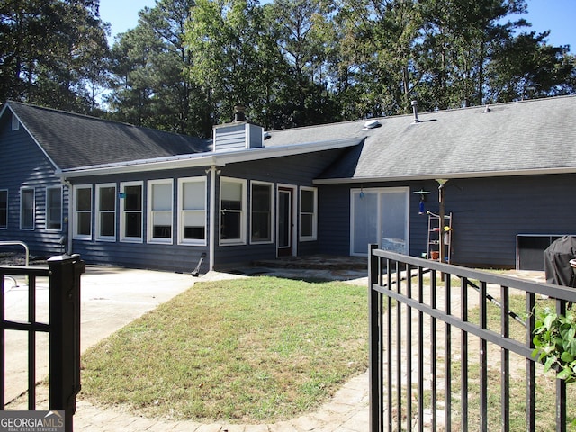 back of house featuring a lawn