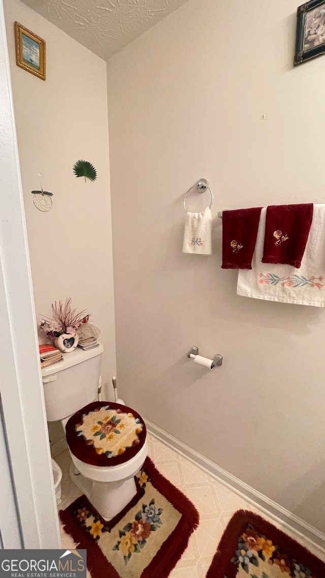 bathroom with a textured ceiling and toilet