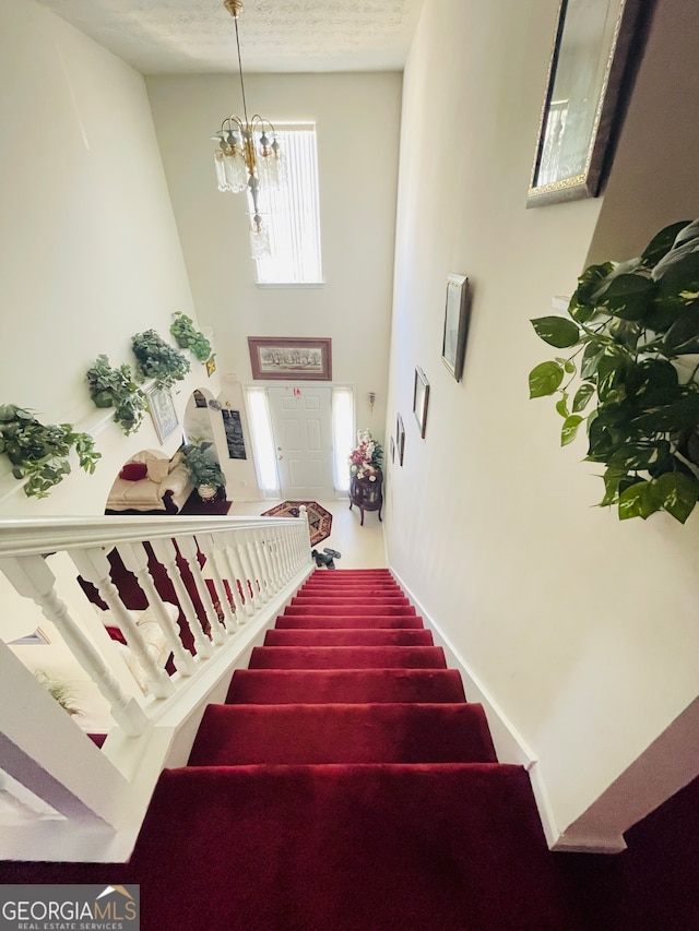 stairs with an inviting chandelier