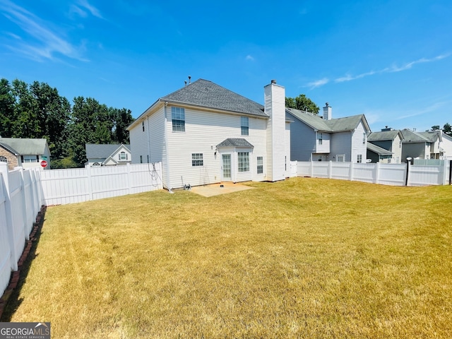 back of house with a patio and a lawn