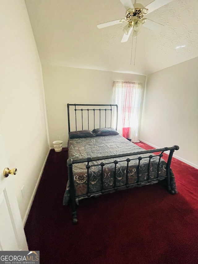 carpeted bedroom with lofted ceiling, a textured ceiling, and ceiling fan