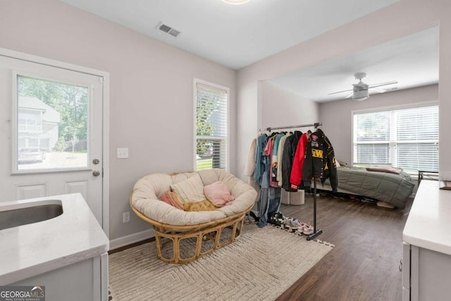 interior space with multiple windows, dark hardwood / wood-style floors, and ceiling fan