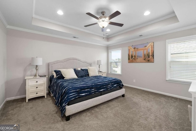 bedroom featuring multiple windows, a tray ceiling, and crown molding