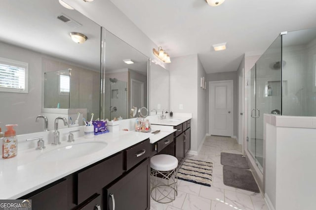 bathroom featuring a shower with door and vanity