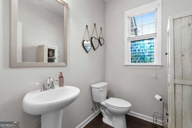 bathroom with toilet, hardwood / wood-style flooring, and sink