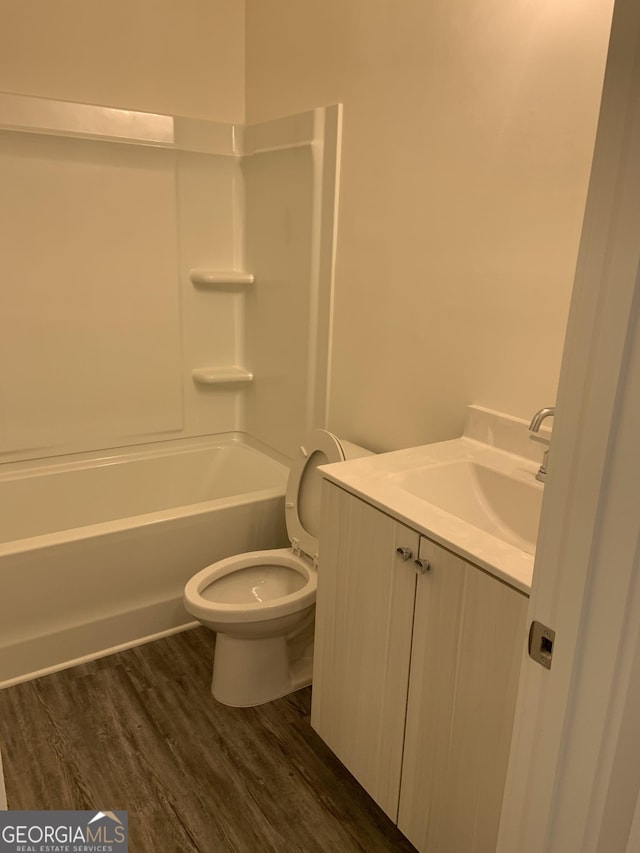 full bathroom featuring toilet, vanity, washtub / shower combination, and hardwood / wood-style floors