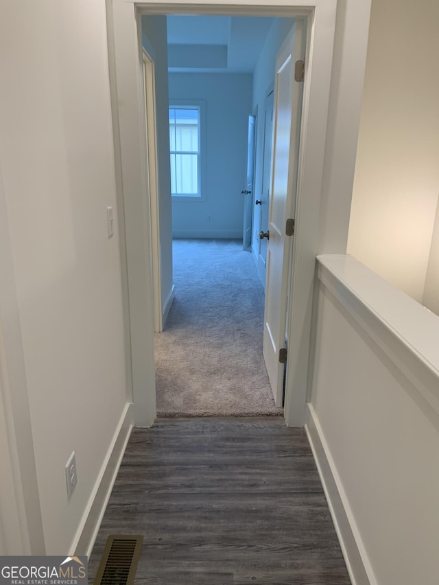 corridor featuring dark colored carpet