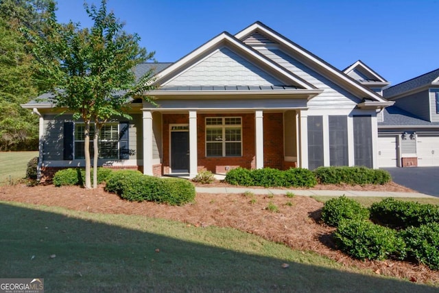 craftsman-style house with a front yard, a porch, and a garage