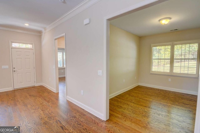 entrance foyer with ornamental molding and hardwood / wood-style flooring