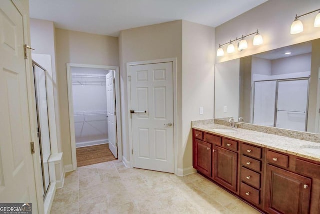 bathroom featuring vanity, walk in shower, and tile patterned flooring