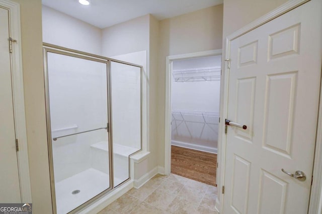 bathroom featuring walk in shower and tile patterned flooring