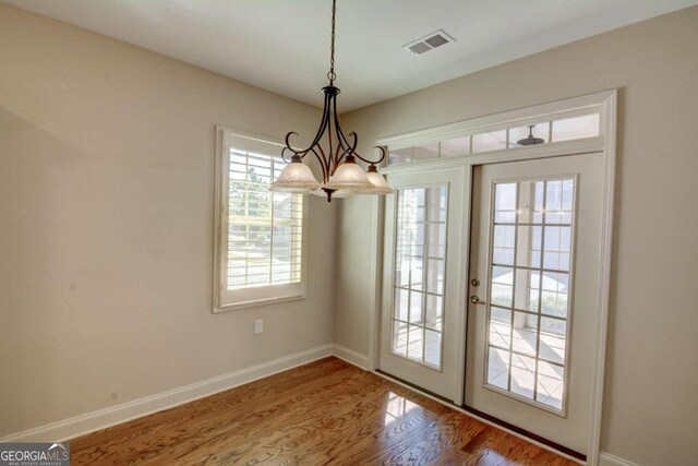 doorway featuring a chandelier and hardwood / wood-style floors