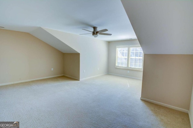 bonus room with vaulted ceiling, light colored carpet, and ceiling fan