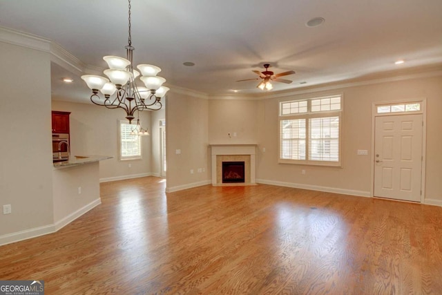 unfurnished living room featuring light hardwood / wood-style floors, crown molding, and plenty of natural light