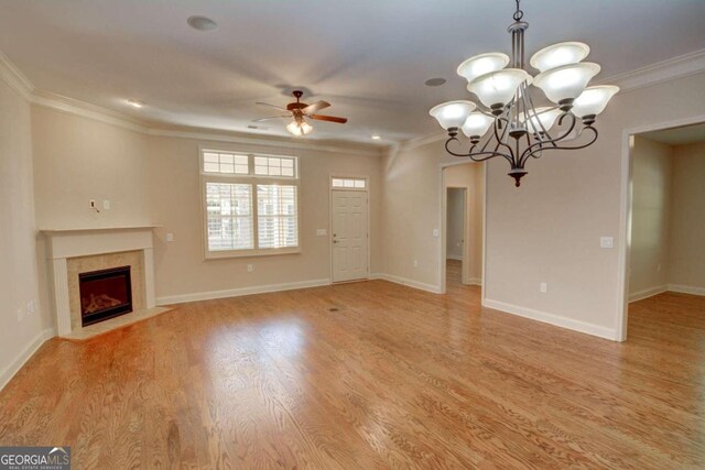 unfurnished living room featuring crown molding, ceiling fan with notable chandelier, and light wood-type flooring