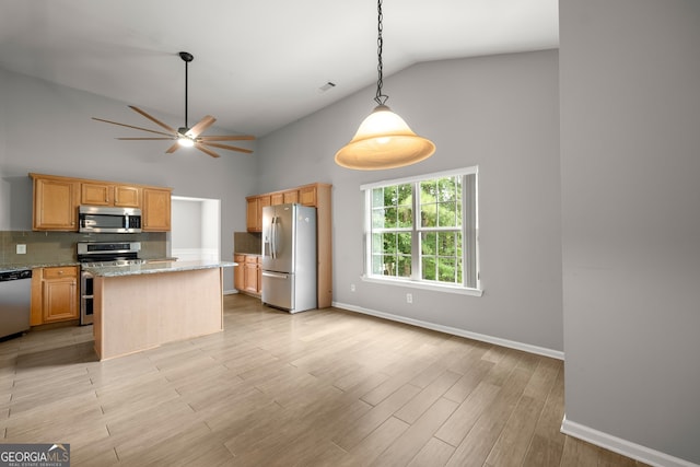 kitchen with light hardwood / wood-style floors, stainless steel appliances, light stone countertops, a center island, and high vaulted ceiling