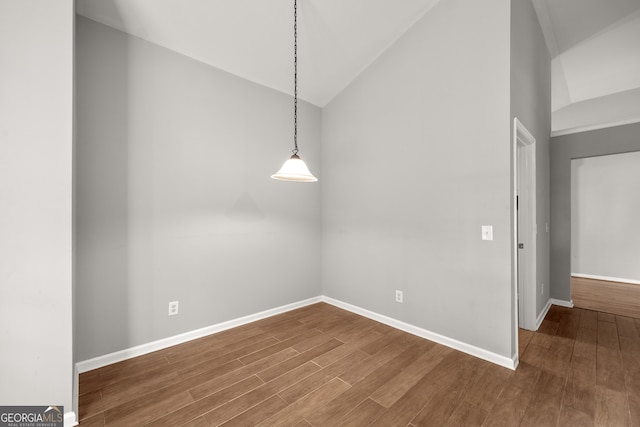 unfurnished dining area with hardwood / wood-style flooring and vaulted ceiling