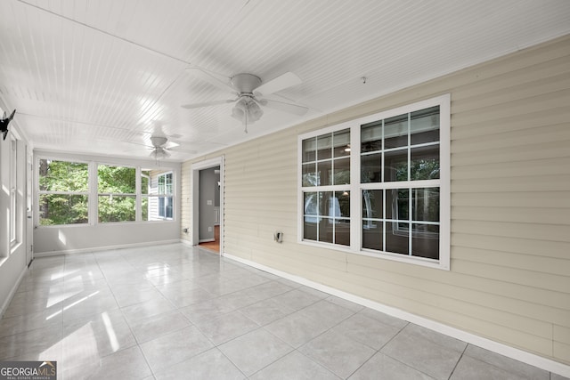 unfurnished sunroom with ceiling fan