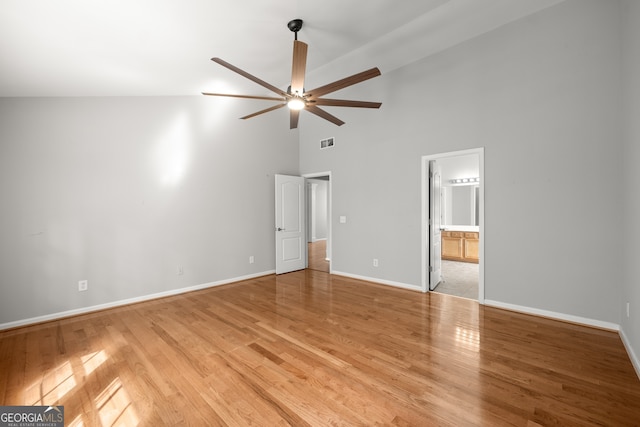 unfurnished bedroom with connected bathroom, ceiling fan, high vaulted ceiling, and light hardwood / wood-style flooring