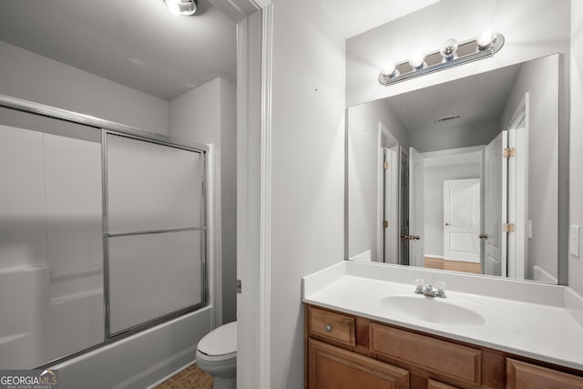 full bathroom featuring vanity, toilet, and bath / shower combo with glass door