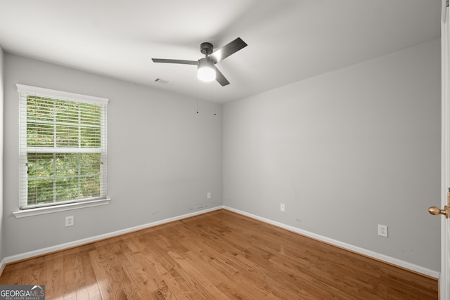 spare room featuring hardwood / wood-style floors, a healthy amount of sunlight, and ceiling fan