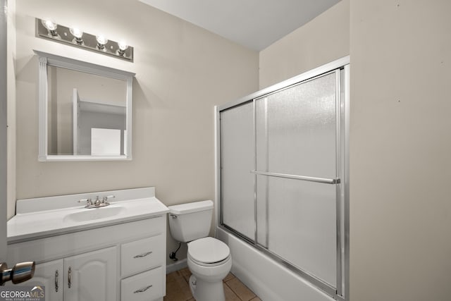 full bathroom with vanity, combined bath / shower with glass door, toilet, and tile patterned flooring