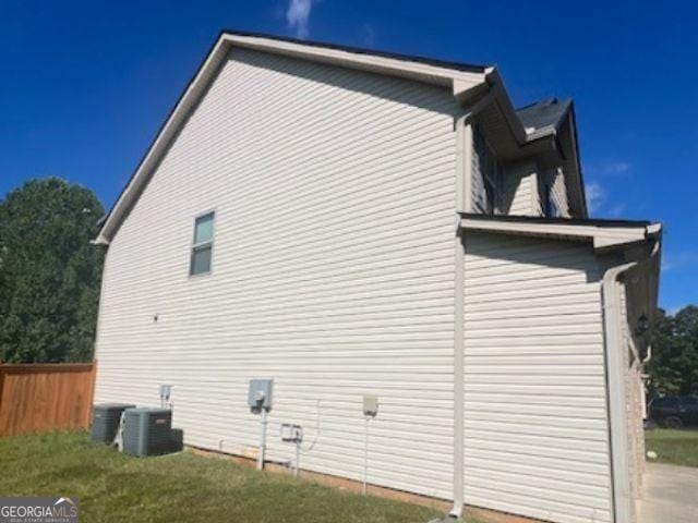 view of side of home with central AC