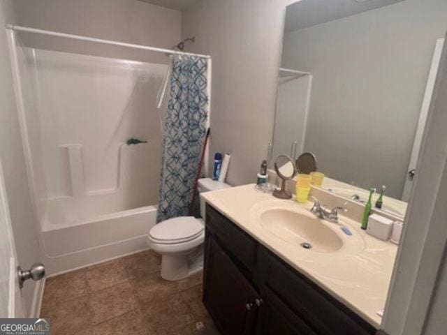 full bathroom with vanity, shower / tub combo, toilet, and tile patterned floors