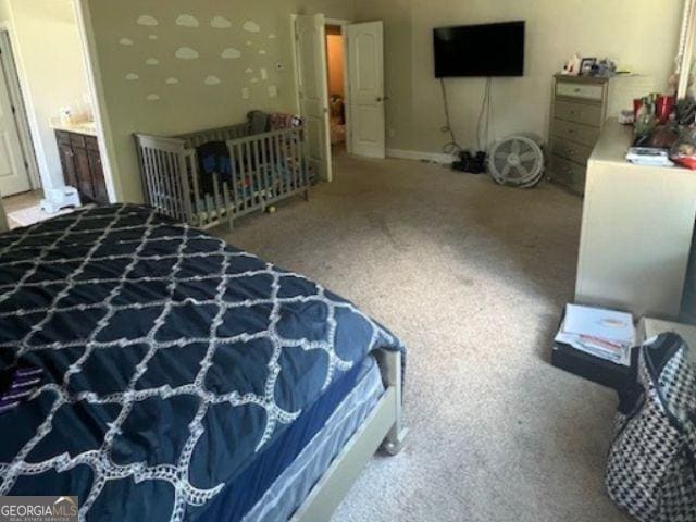 bedroom featuring ensuite bath and carpet floors