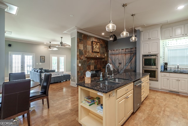 kitchen featuring ceiling fan, appliances with stainless steel finishes, sink, french doors, and decorative light fixtures