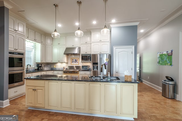 kitchen with appliances with stainless steel finishes, a kitchen island with sink, sink, and hanging light fixtures