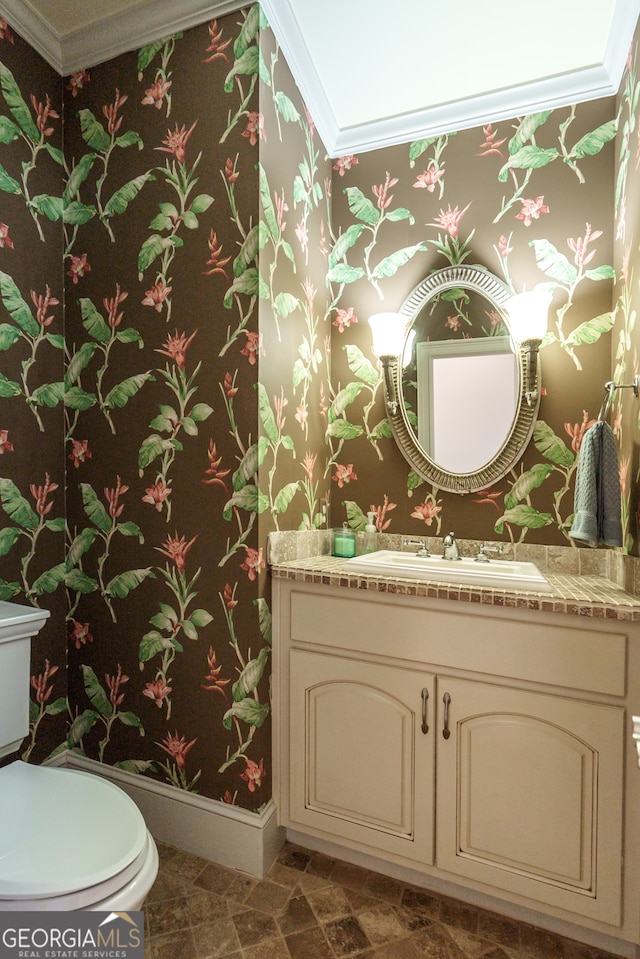 bathroom featuring toilet, crown molding, and vanity